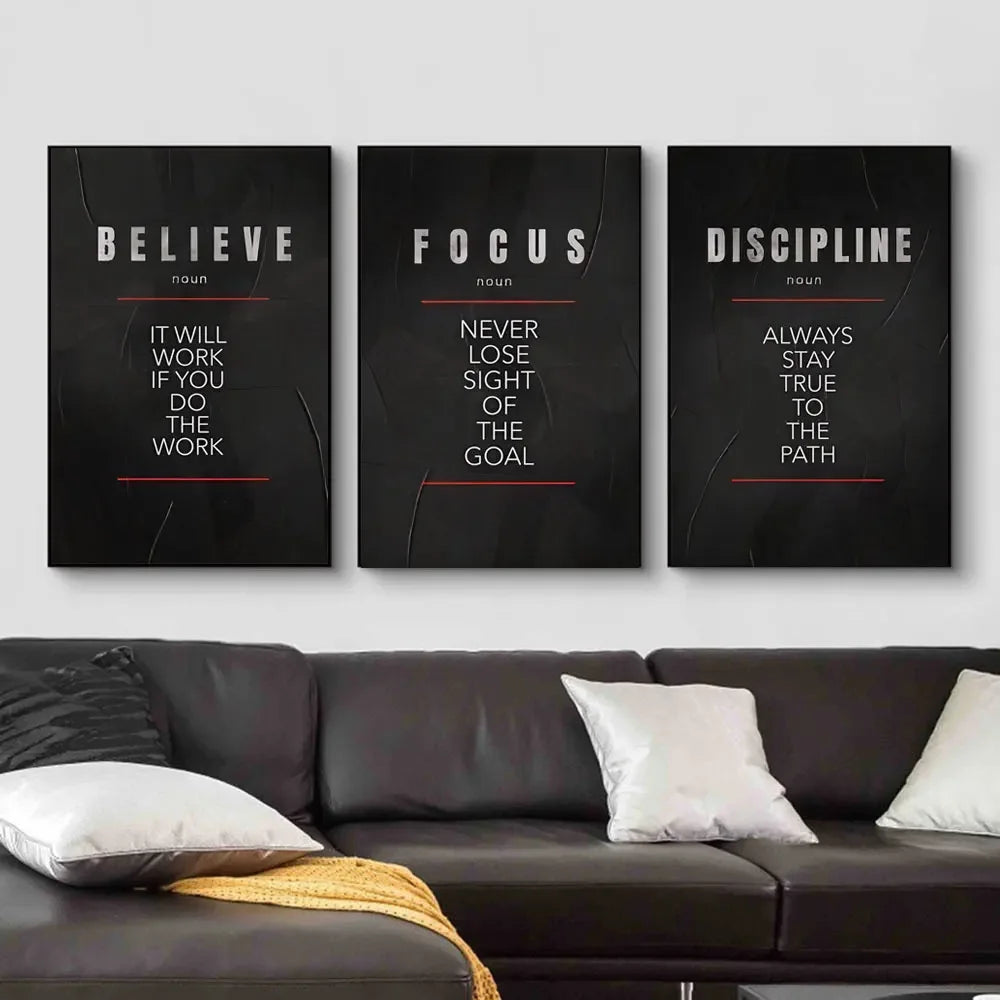 Three framed motivational canvas prints titled Believe Focus and Discipline displayed on a white wall.