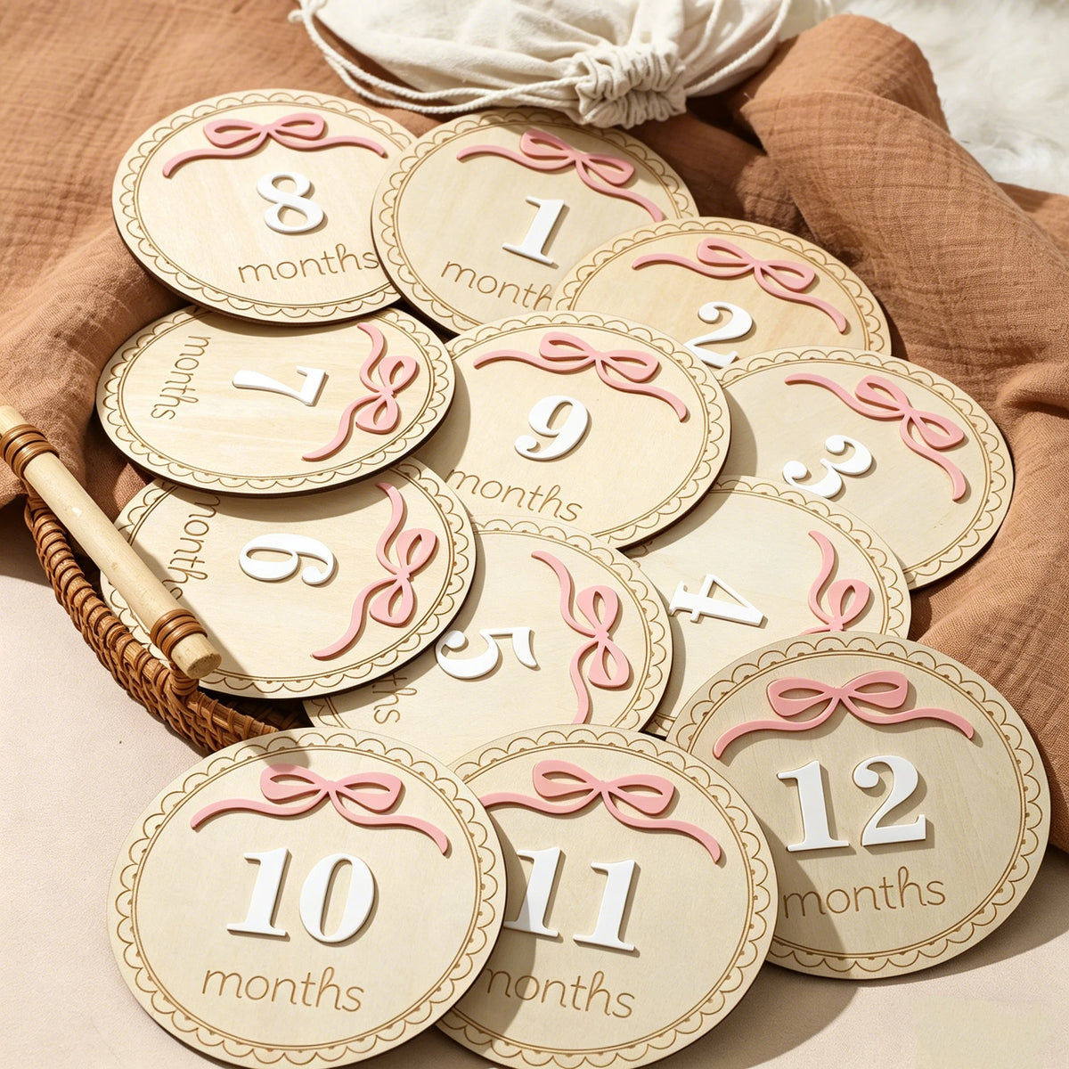 A collection of wooden baby milestone cards showing numbers 1 through 12 for newborn keepsakes