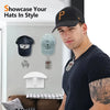 A man wearing a black baseball cap is shown next to various hat hooks and storage accessories on a white wall.