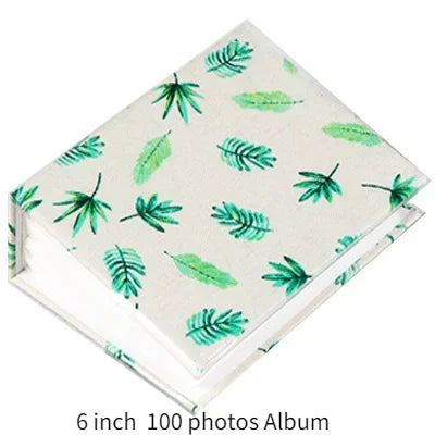 A square memory album with a light background decorated with green leaf illustrations.