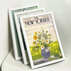 A set of three white picture frames displaying a vintage New Yorker magazine cover.
