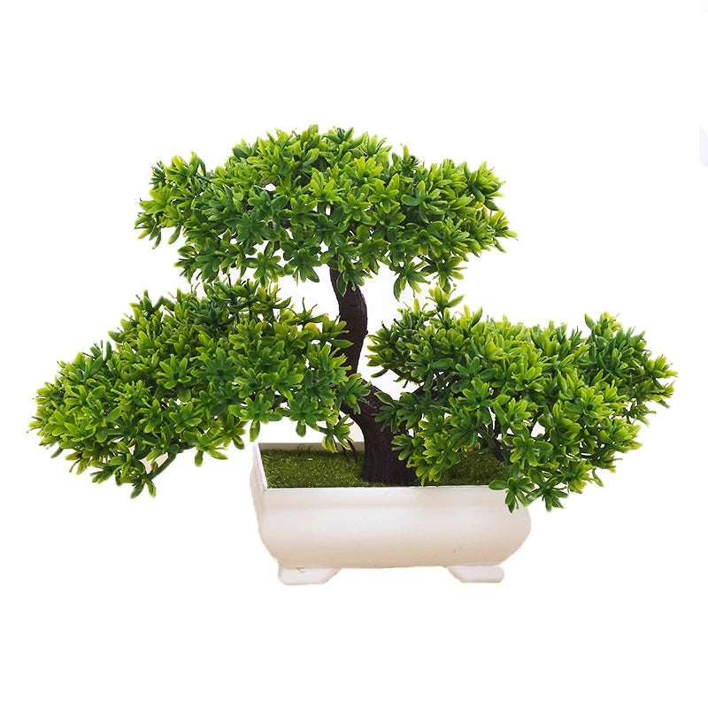 A small artificial tree bonsai decoration with vibrant green foliage planted in a white rectangular pot.
