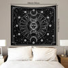 Black tapestry wall hanging featuring a psychedelic sun and moon mandala design with stars and celestial elements.