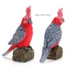 A hand-painted resin parrot figurine with red and gray feathers, shown in profile.
