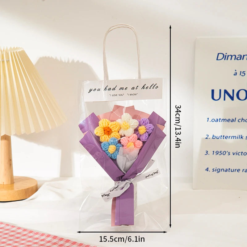 A clear plastic bag containing a handmade crochet sunflower mini bouquet wrapped in purple paper.