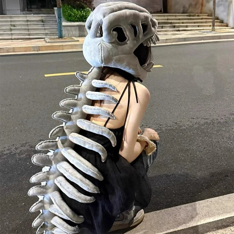 A person wearing a wearable dinosaur skeleton costume with a head and spine, standing outdoors.
