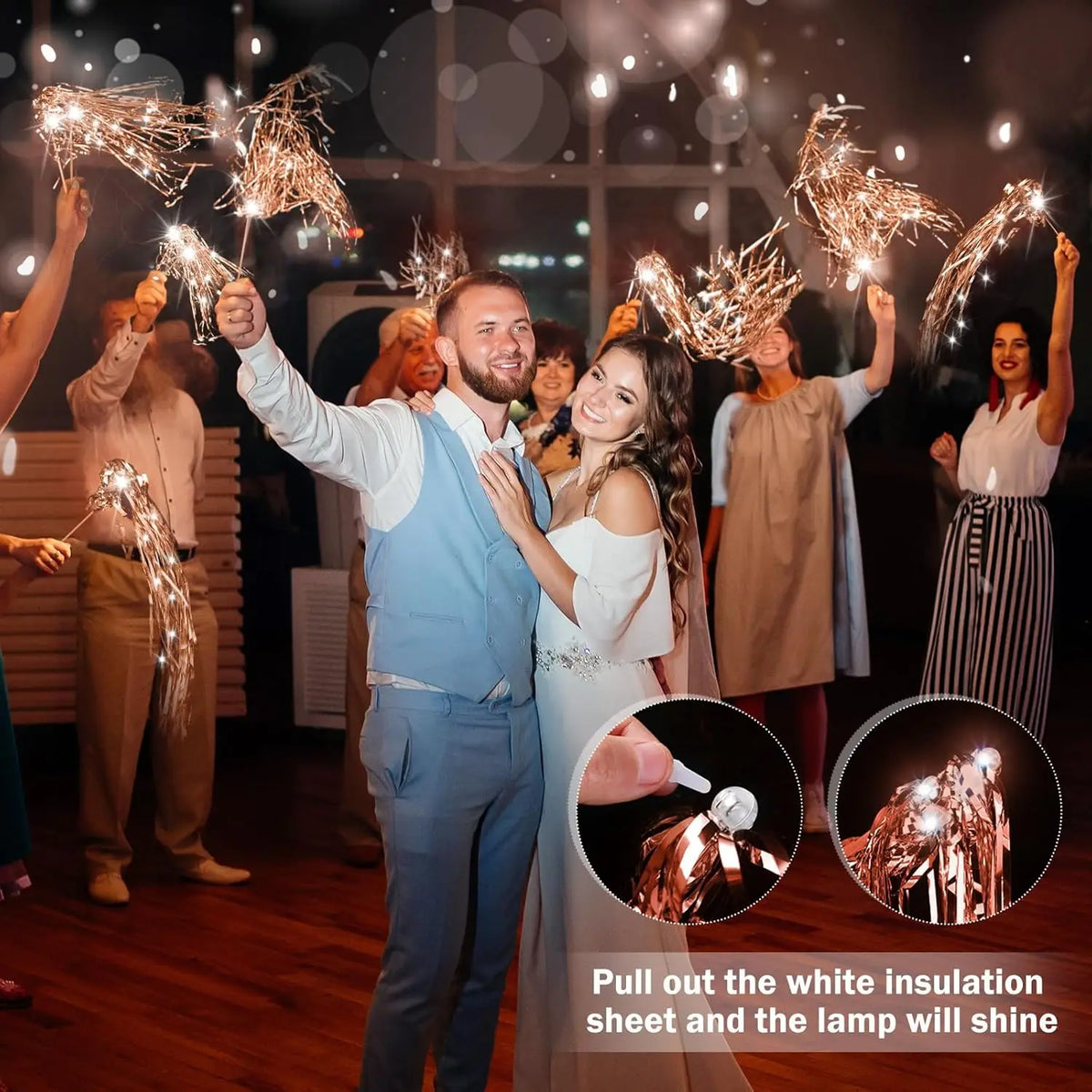 A groom is celebrating with lighted tinsel wedding wands while a bride stands beside him.