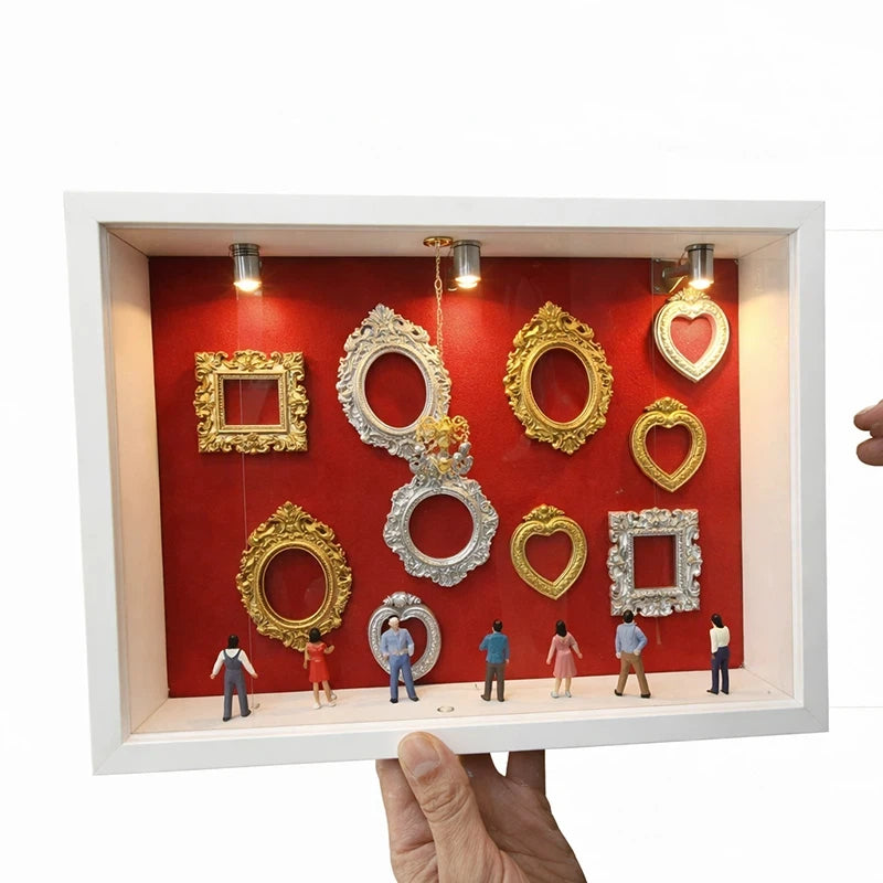 Eine Präsentationsbox mit verschiedenen Gold- und Silber-Silhouettenrahmen auf rotem Hintergrund.