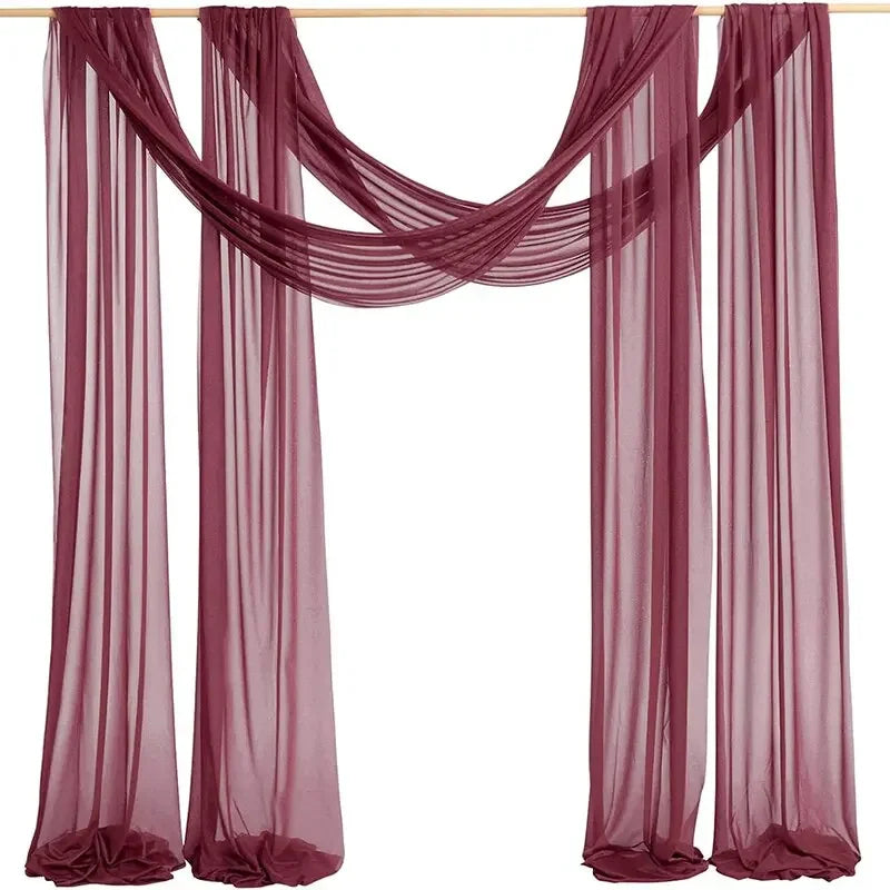 A set of two sheer mauve chiffon fabric panels draped for a wedding arch backdrop.