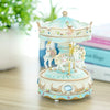 A handmade resin carousel music box with a light blue and pink painted design featuring horses.