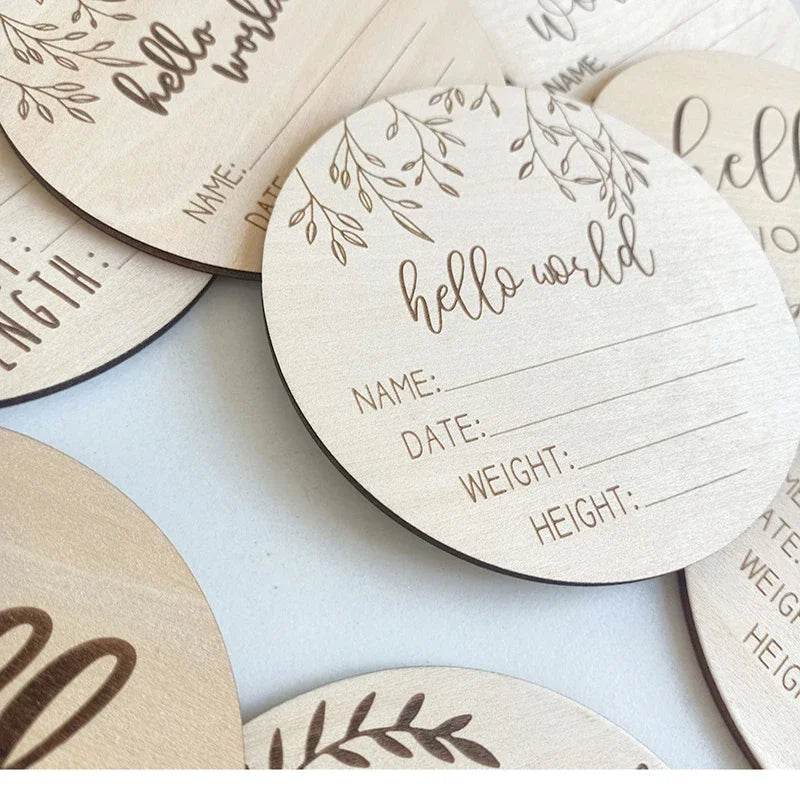 A collection of natural wood baby milestone discs with engraved details for newborn photography.