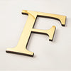 A gold acrylic mirror letter F wall sticker, 20cm in size.
