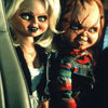 A close-up photo of a doll resembling Chucky, with pale skin and red hair, looking intensely at the camera.