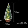 A small, illuminated LED Christmas tree with a snow effect, approximately 30cm tall and weighing 87g.