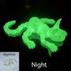 A glowing green realistic Sphynx cat fidget toy shown in daylight and night contexts.