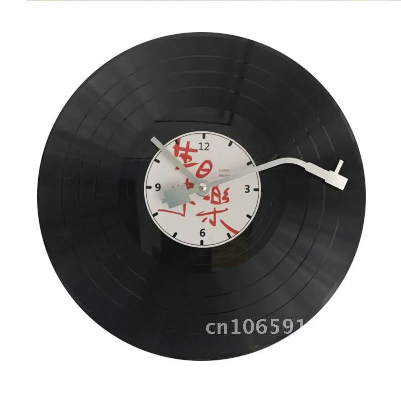 A black vinyl record is mounted on a wall clock with white markings and a silver hand.
