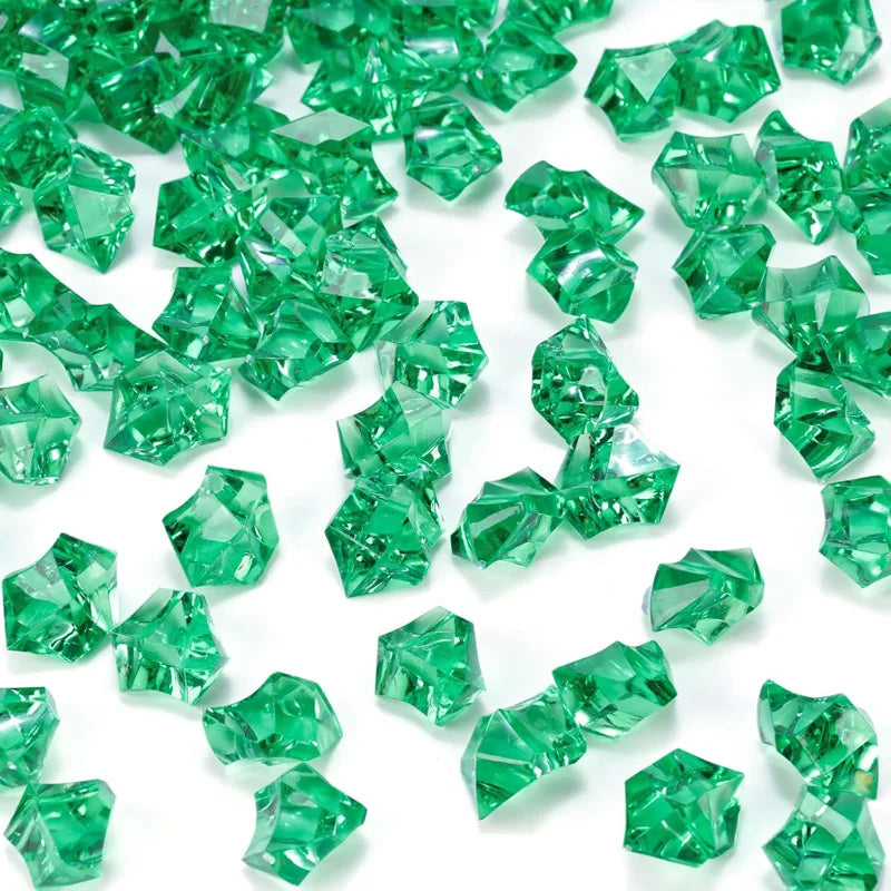 Green decorative crushed diamond acrylic pebbles scattered on a white background