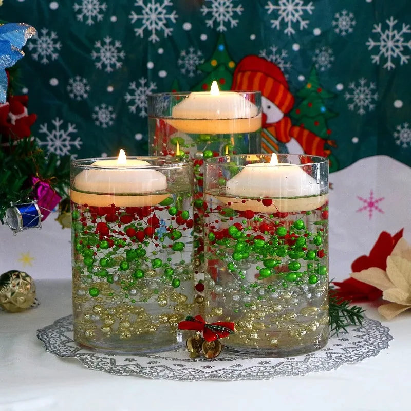 Three glass jars filled with water and green and red floating candles set against a Christmas-themed background