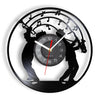 A black wall clock face featuring silhouettes of musicians playing instruments and musical notes around the edge.