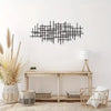 Black geometric metal wall art featuring an abstract sculpture design mounted on a white wall.