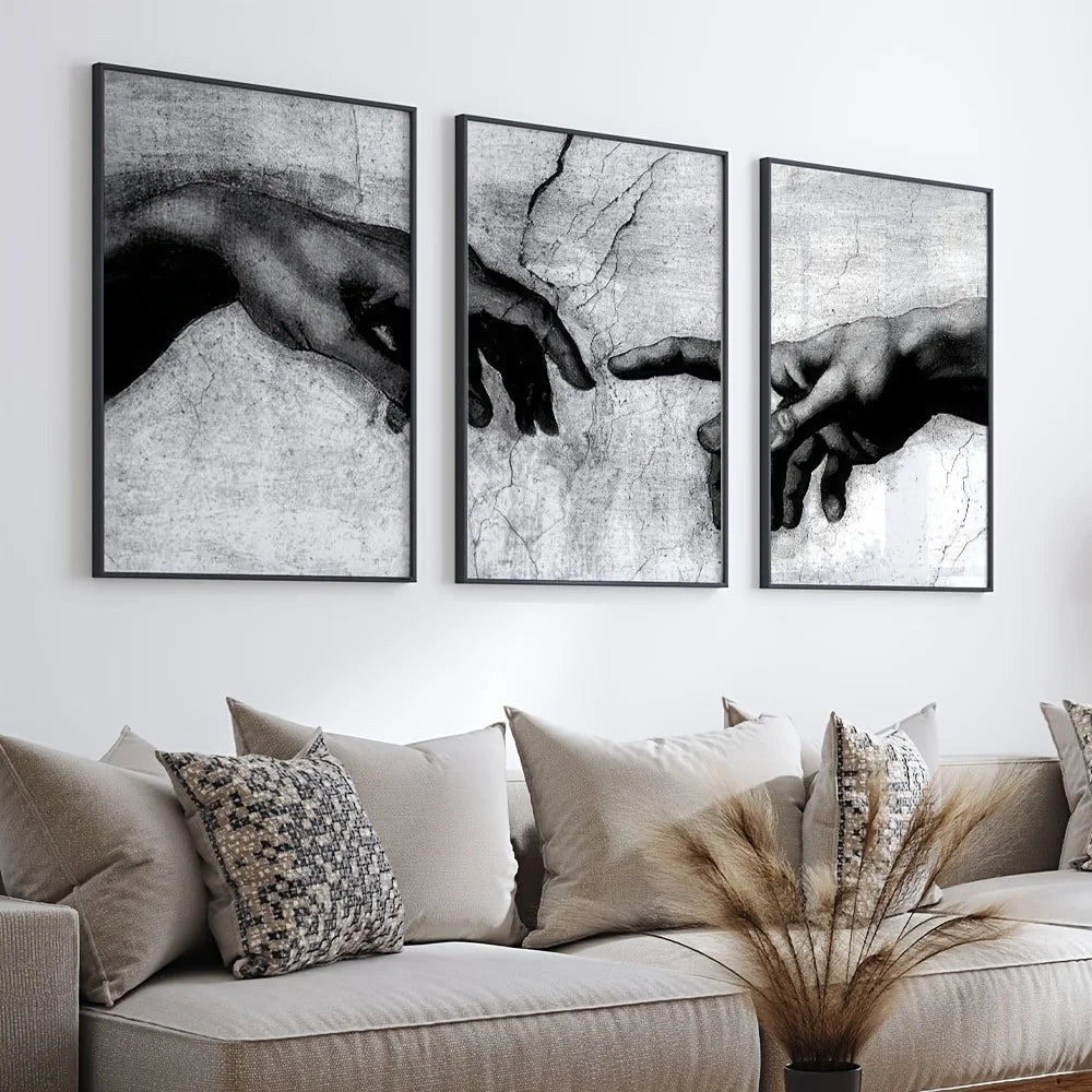 A set of three black and white canvas prints depicting hands, used as wall art.