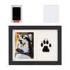 A black wooden photo frame displaying a paw print design, with a separate ink pad and frame components shown.