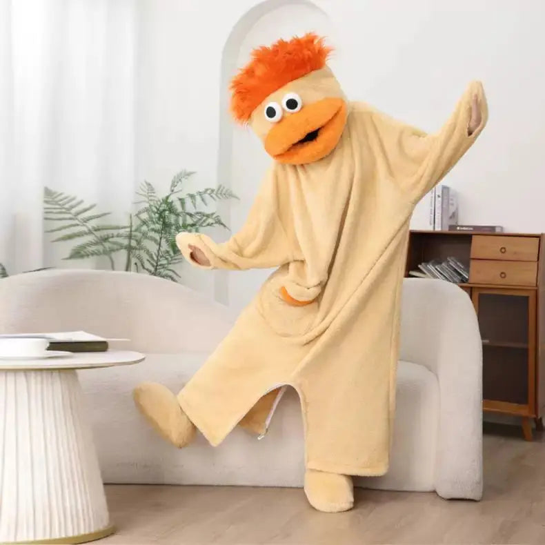 A fluffy, orange monster onesie pajama suit is displayed on a white couch.