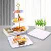 A gold-colored three-tiered serving stand displaying various colorful desserts and pastries on white plates.