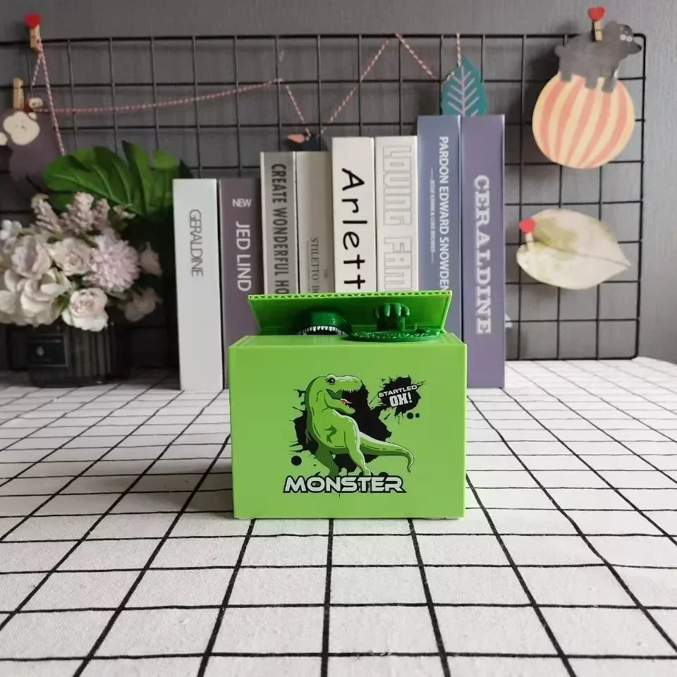 A green interactive coin bank with a monster design sits in front of a shelf of books.