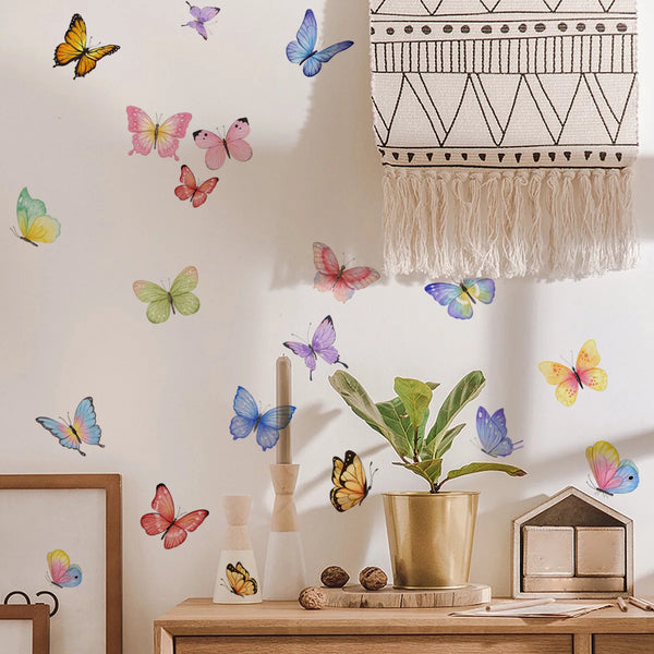 A gallery wall featuring watercolor butterfly decals on a white wall above a wooden shelf.