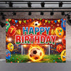 A vibrant soccer field party backdrop featuring a football, balloons, and birthday text on a brick wall.