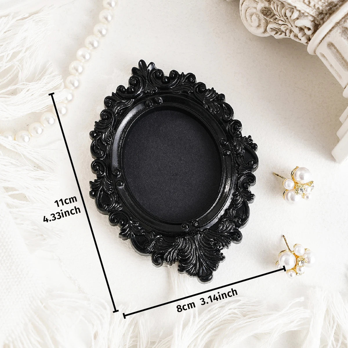 Black ornate frame wall decor pendant with pearl accents shown on a white surface.