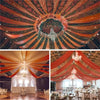 A dramatic ceiling installation featuring dark green sheer chiffon curtains and orange draping for a wedding event.