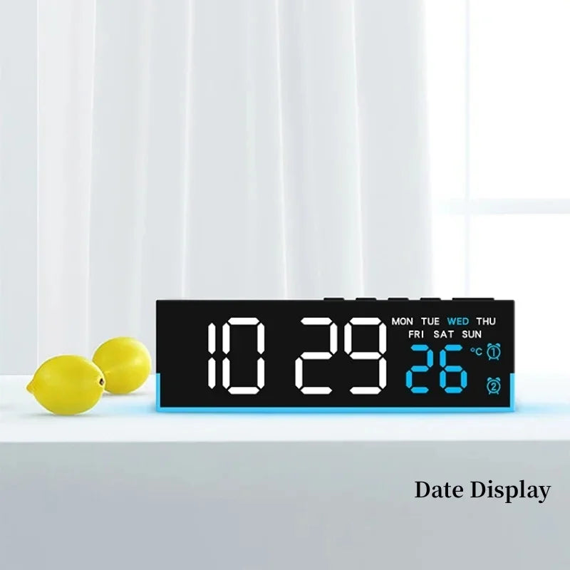A digital alarm clock display showing the date and temperature on a white surface.