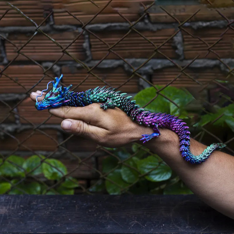 A hand holds a vibrant, color-changing flexible dragon figurine against a dark, textured background.
