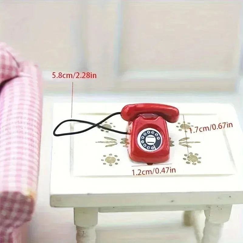 A red retro rotary desk phone miniature is shown on a white surface with dimension markings.