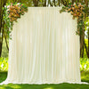 A cream fabric backdrop curtain decorated with floral greenery and roses outdoors.