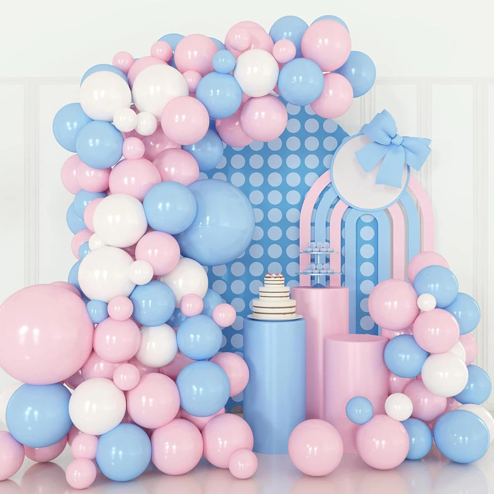 A large arrangement of pink and blue latex balloons forming a decorative backdrop.