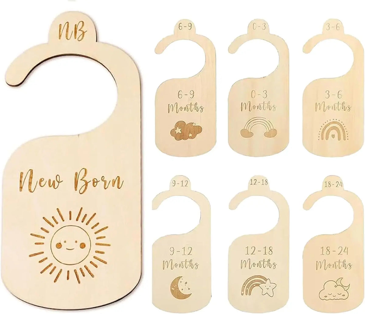 A set of seven wooden baby closet dividers featuring rainbow and cloud designs for newborn to three-six months.