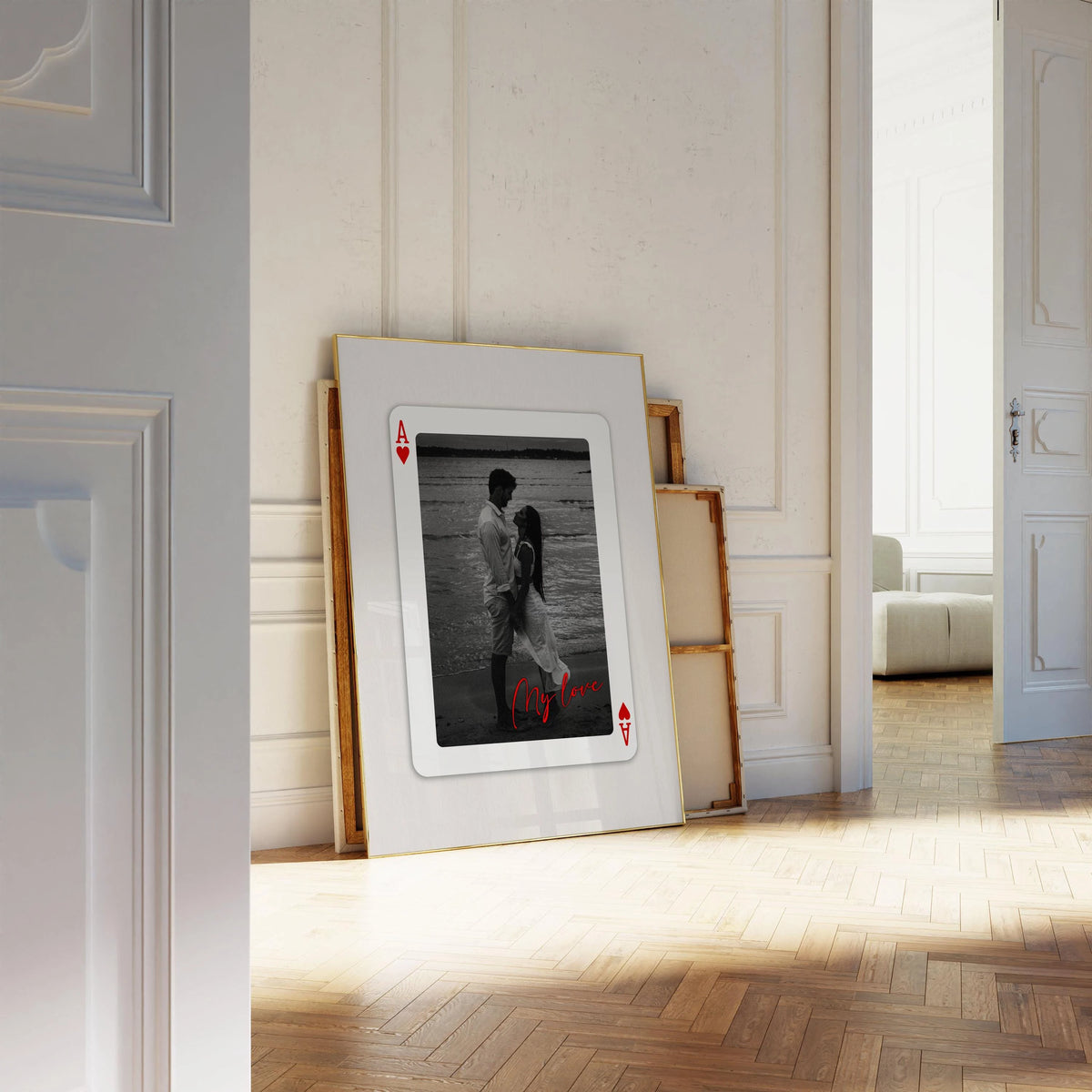 A framed playing card featuring a black and white photo of a couple, presented in a light wood frame.