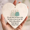A white heart-shaped acrylic pendant featuring a tree design and two silhouette figures, with text about relationships.