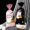 Two black and pink Halloween candy treat bags with cute ghost and cat designs displayed on a white surface.