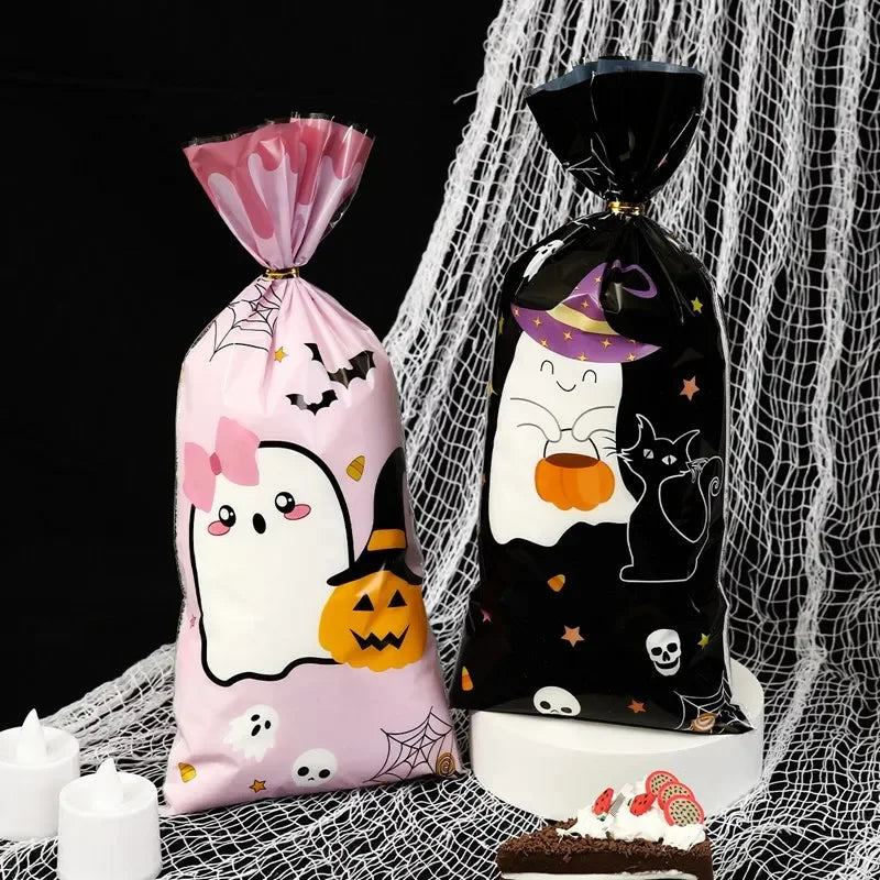 Two black and pink Halloween candy treat bags with cute ghost and cat designs displayed on a white surface.