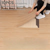 Ten pieces of self-adhesive wood grain decor stickers being applied to a wooden floor surface.