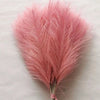 A fluffy pink artificial pampas grass stem used for boho wedding and home decor.