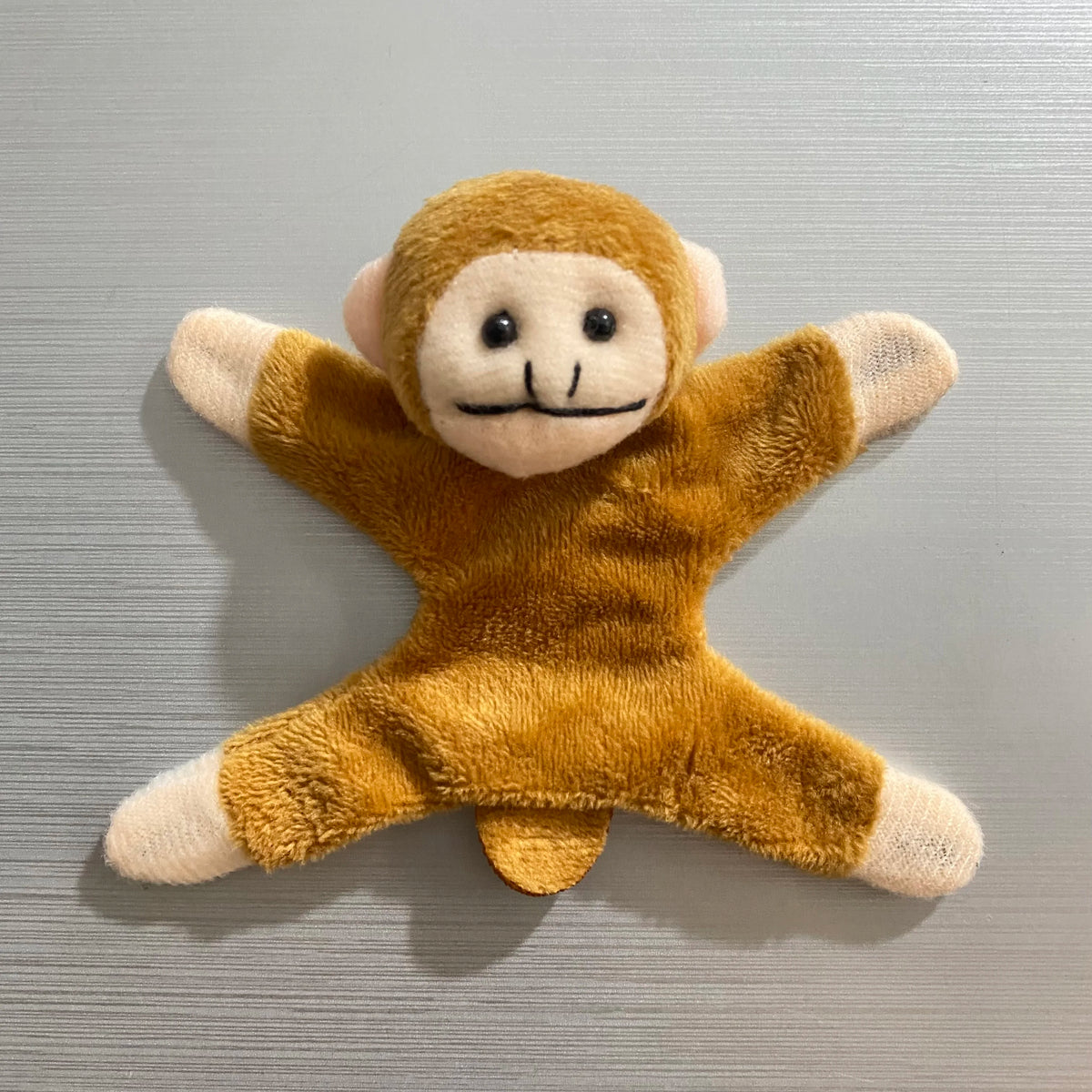 A fluffy, golden-brown elephant plush toy with light beige accents.
