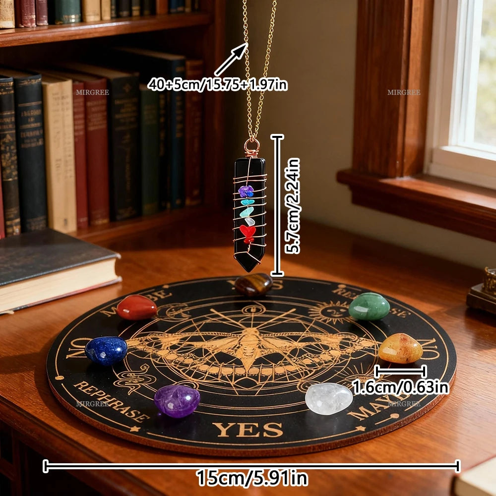 Un long collier or avec un pendentif noir et des cristaux colorés, exposé au-dessus d'un jeu de divination en bois.