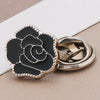 A black rose-shaped no-sew brooch button with a silver-toned metal setting.
