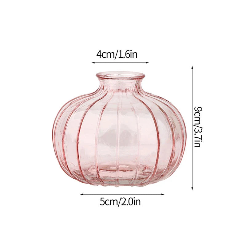 A pink, ribbed glass vase with a rounded body and narrow neck.