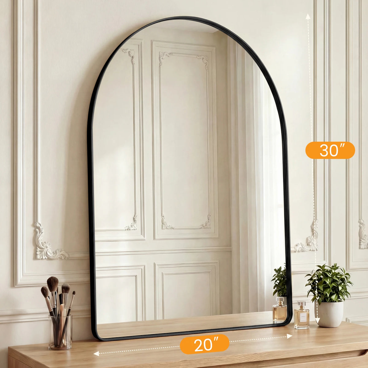 An arched full-length wall mirror with a matte black frame displayed on a wooden surface.